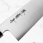 Close-up of a chef's knife blade with black text on a white background